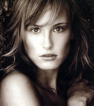 Wispy side bangs with heavily layered hair framing the face.