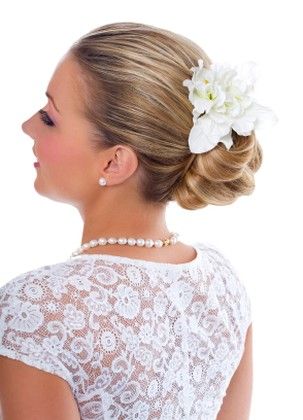 Young bride wearing pearls and lace top with wedding updo hairstyle with
