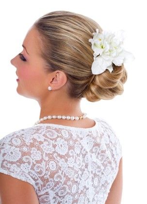 Young bride wearing pearls and lace top with wedding updo hairstyle with 