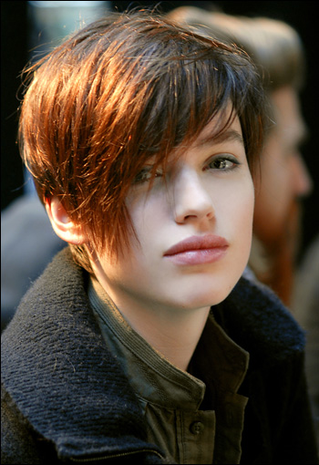 Short red hair was blow-dried smooth with a long sweeping fringe