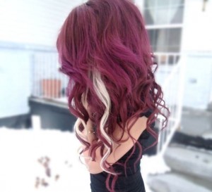 Deep red curly hair with white streaks on one side